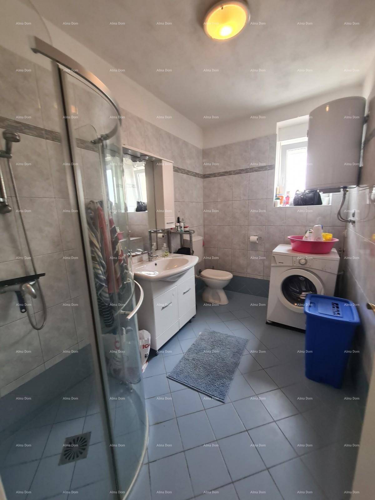 Badezimmer mit Duschkabine, Waschbecken, Toilette und Waschmaschine, hell gefliest und funktional.