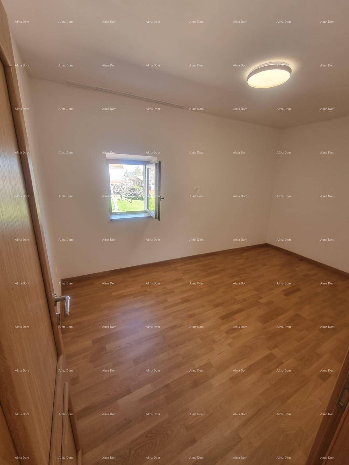 Helles Schlafzimmer mit Holzboden und einem kleinen Fenster, das Tageslicht hereinlässt.