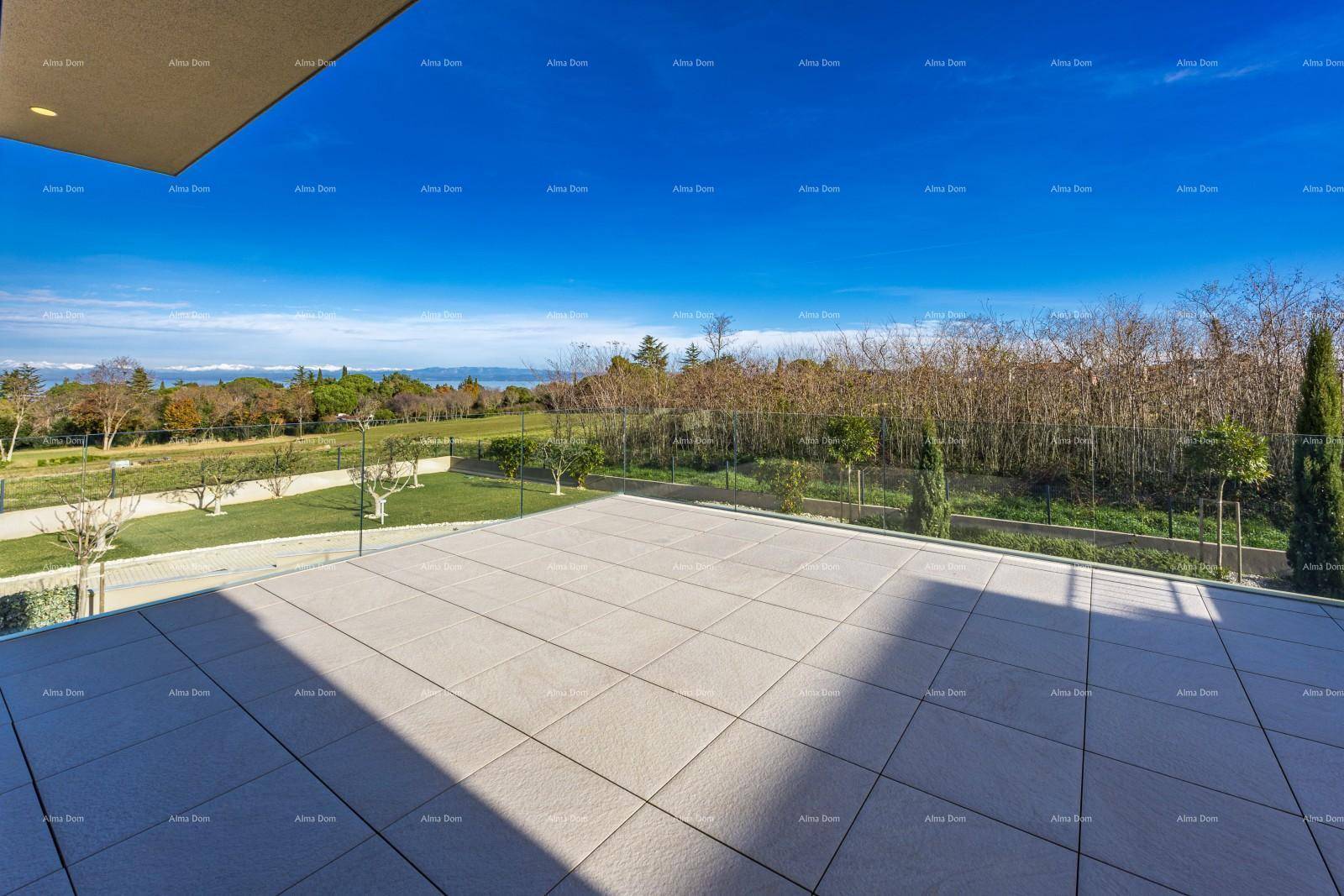 Weitläufige Terrasse mit Fliesenboden und Panoramablick auf die grüne Landschaft und das Meer.