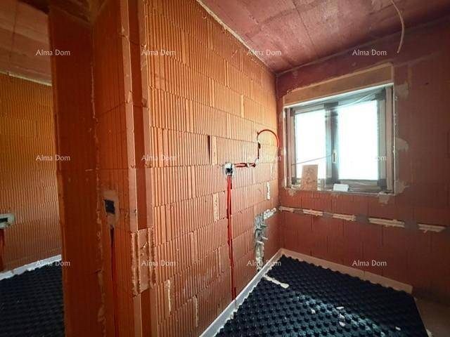 Unfertiges Badezimmer mit Ziegelwänden, Fenster und Vorbereitung für Sanitärinstallationen.
