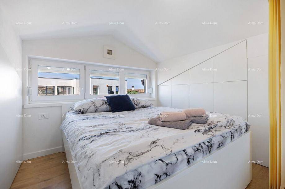 Helles Schlafzimmer mit modernem Bett, Fenster und Einbauschränken unter dem Dach.