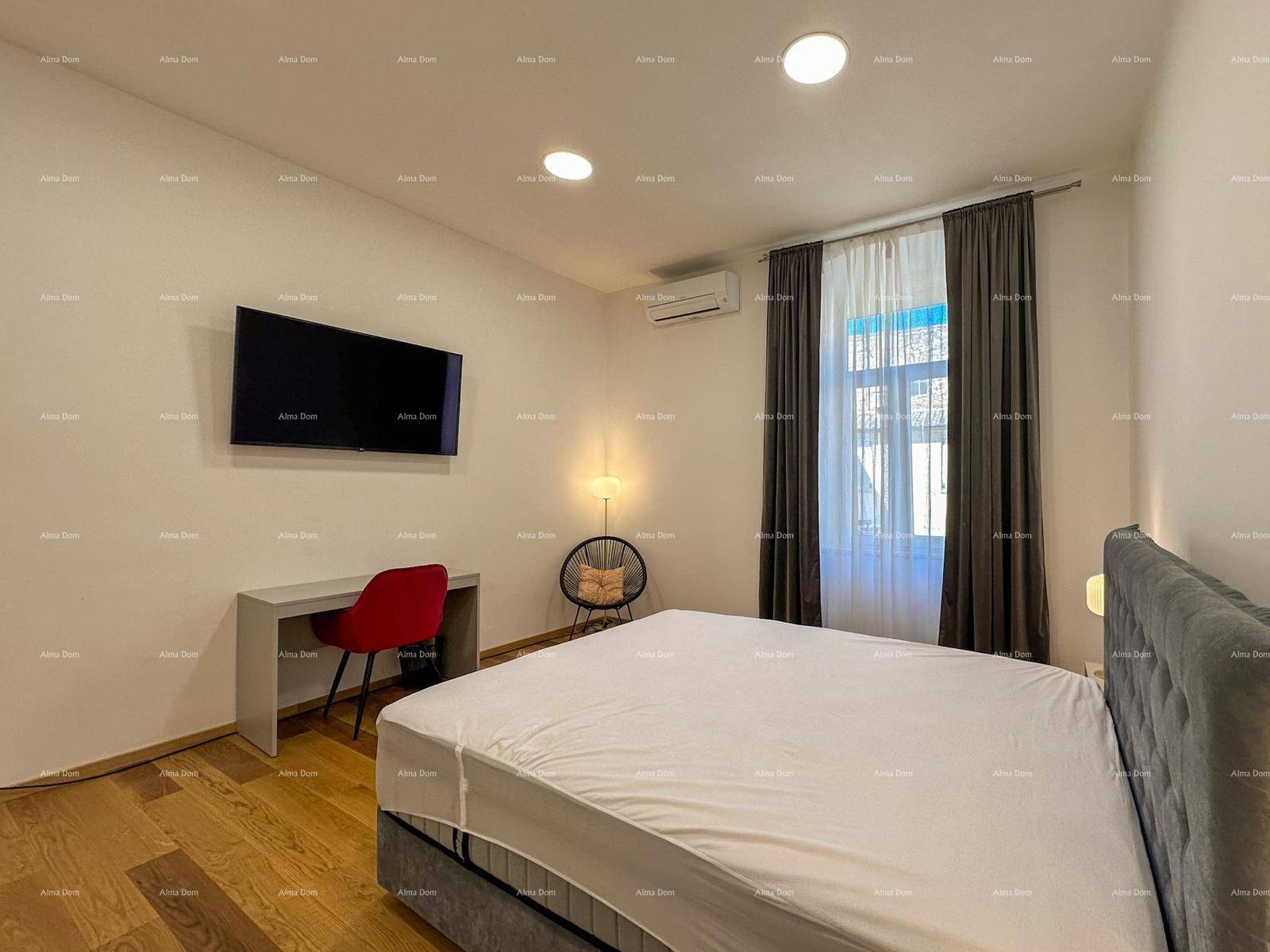 Schlafzimmer mit Holzboden, Fernseher und Schreibtisch, bietet Komfort und Funktionalität.