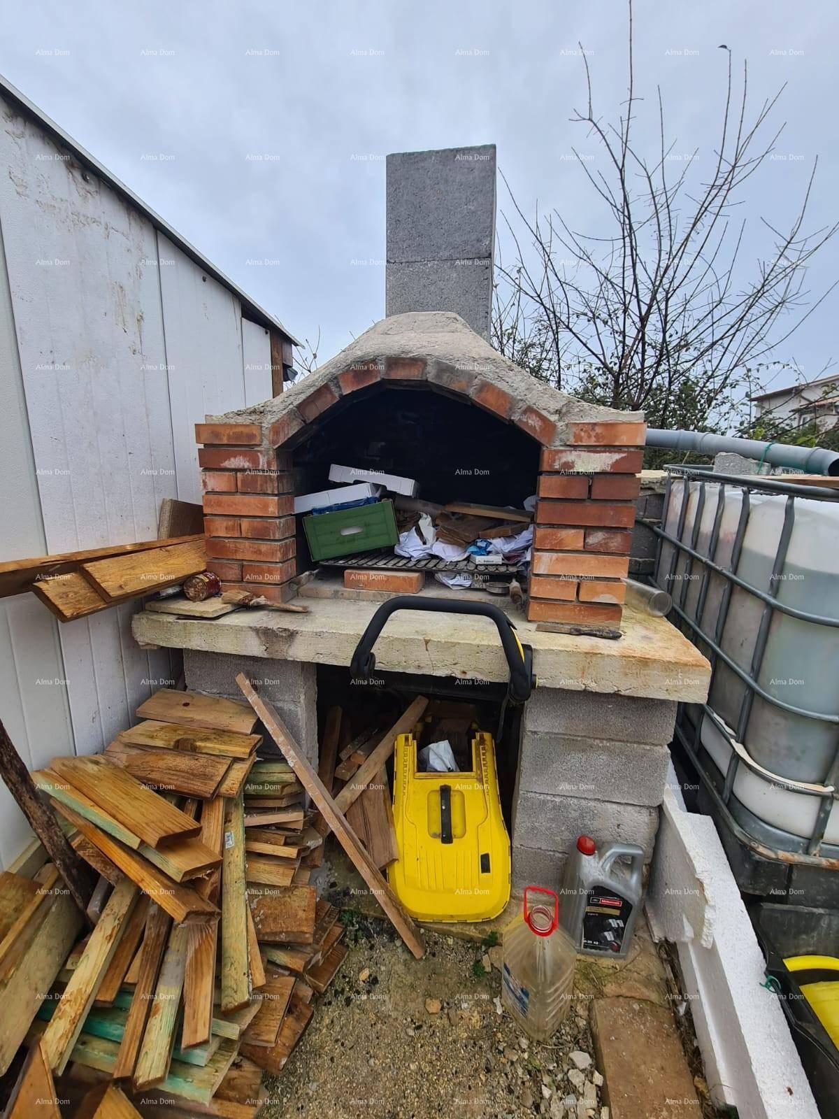 Gemauerter Außenofen oder Grillplatz mit gestapeltem Holz, bereit für die Nutzung im Garten.