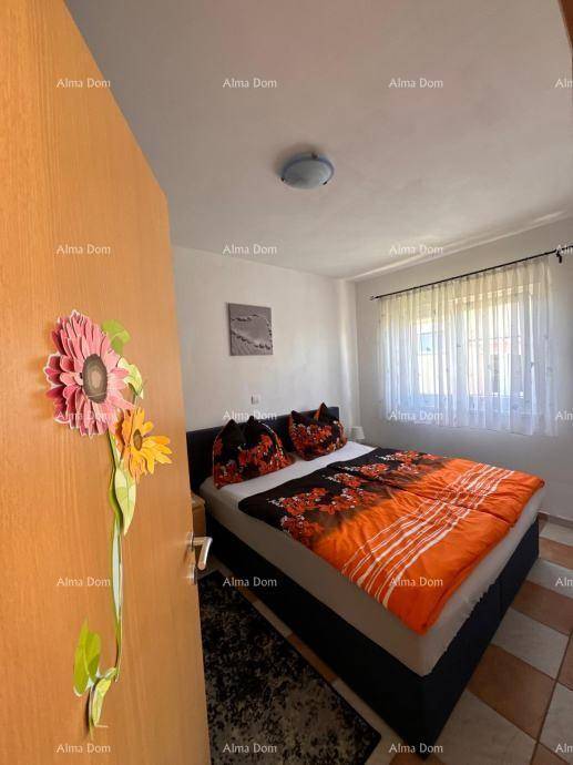 Gemütliches Schlafzimmer mit Doppelbett, farbenfroher Bettwäsche und Fenster mit Vorhängen.
