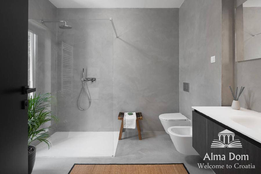 Geräumiges Badezimmer in Grau mit begehbarer Dusche, Bidet und modernem Waschtisch.