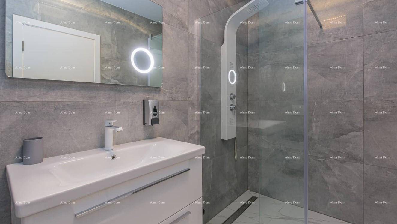 Modernes Badezimmer mit grauem Fliesenboden, Waschtisch und großer Duschkabine.
