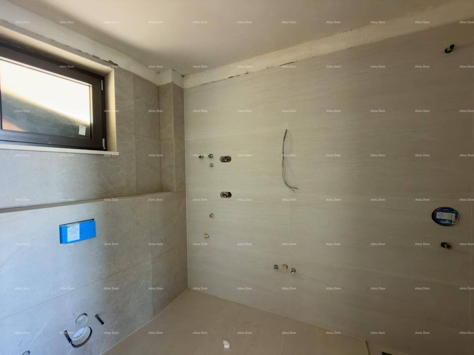 Unfertiges Badezimmer mit gefliesten Wänden und vorbereiteten Anschlüssen für Sanitärinstallationen.