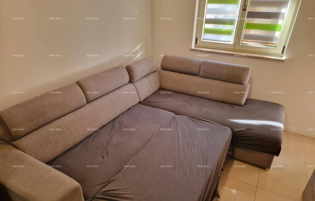 Gemütliches Wohnzimmer mit großem Ecksofa und Fenster mit Jalousien.