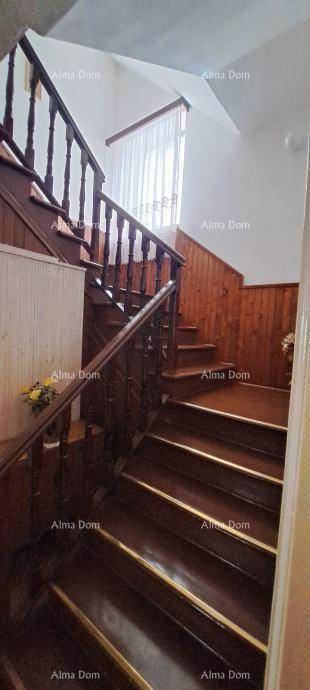Holztreppe mit Geländer und einem Fenster, das natürliches Licht hereinlässt.