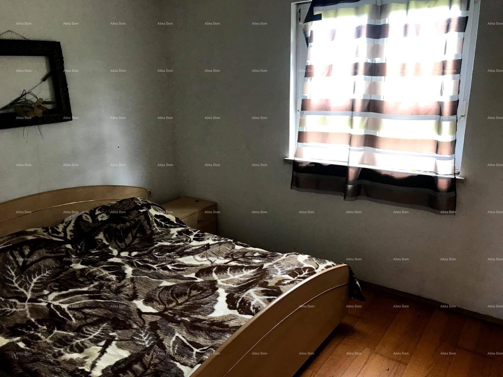 Schlafzimmer mit Holzboden, Doppelbett und Fenster für natürliches Licht.