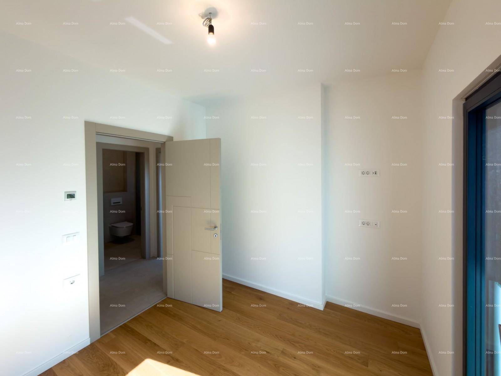 Leeres Schlafzimmer mit Holzboden und Tür, die zu einem modernen Badezimmer führt.