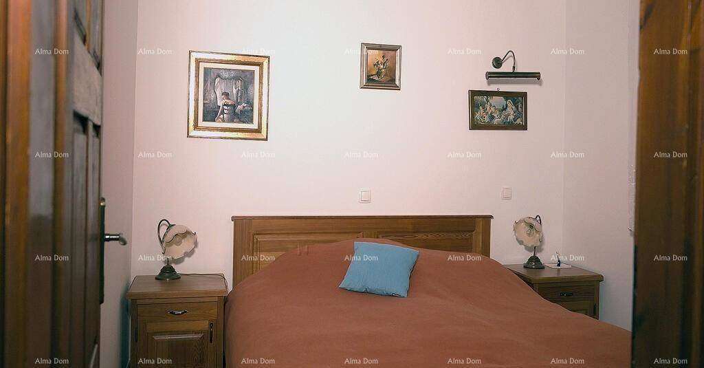 Schlafzimmer mit Doppelbett, zwei Nachttischen und dekorativen Bildern an der Wand.