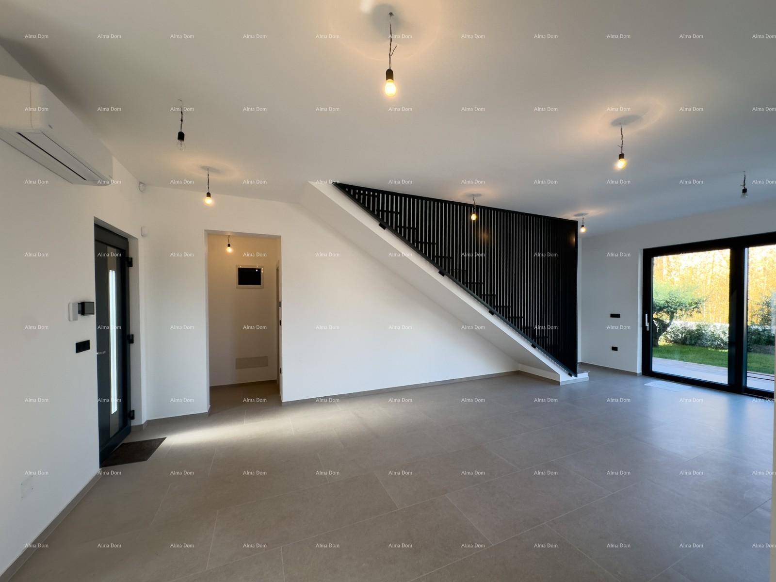 Offener Wohnbereich mit moderner Treppe und großen Glasfronten zum Garten.
