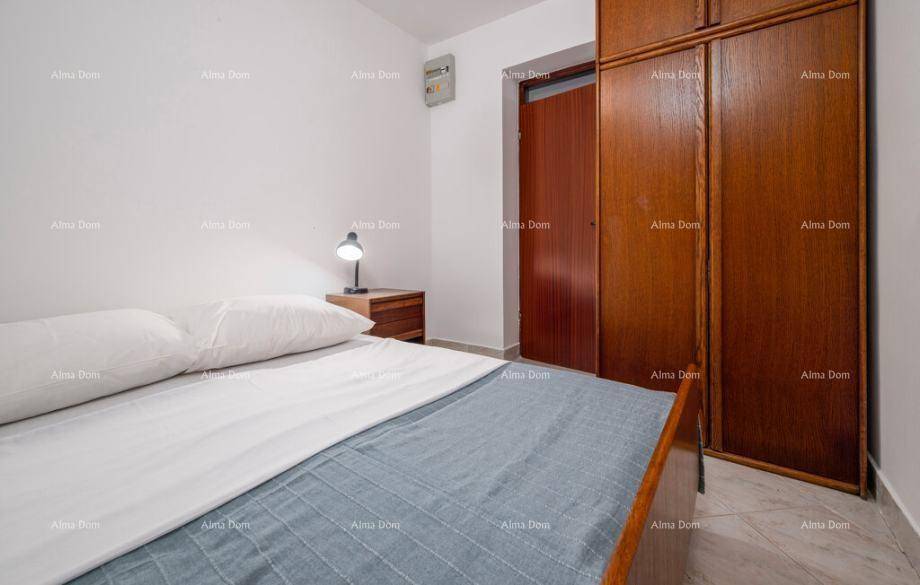 Schlafzimmer mit Holzkleiderschrank, Nachttisch und Leselampe neben dem Bett für Komfort.