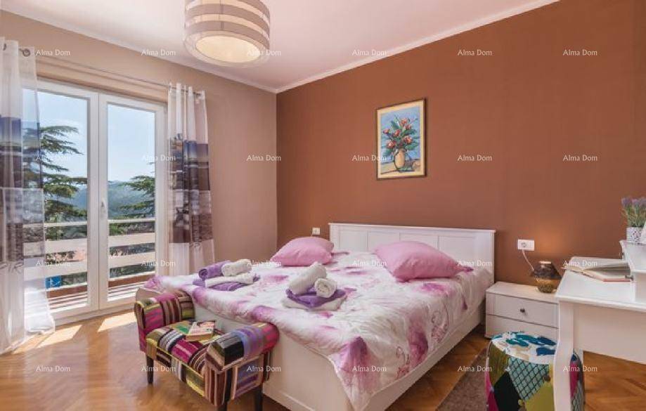 Schlafzimmer mit Doppelbett, Holzboden, brauner Akzentwand und Zugang zu einem Balkon mit Aussicht.