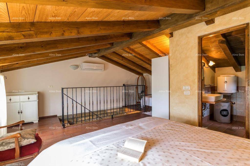 Geräumiges Schlafzimmer im Dachgeschoss mit Holzbalken, Klimaanlage und Blick auf die Galerie.