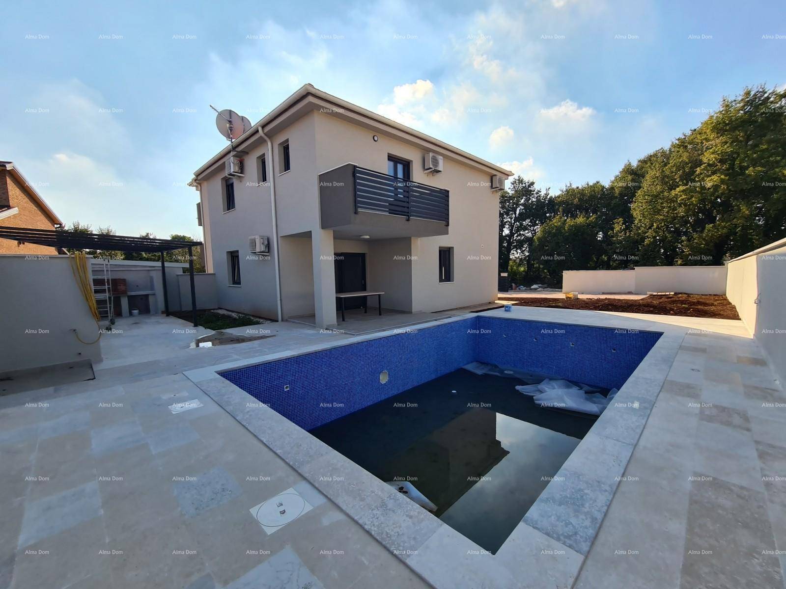 Außenansicht des Hauses mit einem großen, noch unfertigen Swimmingpool und gepflasterter Terrasse.