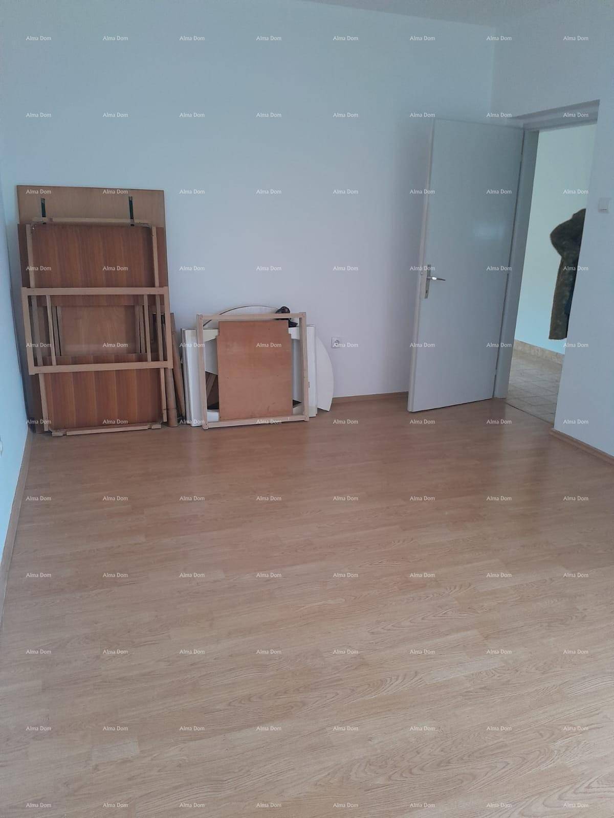Leeres Zimmer mit hellem Laminatboden und einer Tür, bereit zur individuellen Gestaltung.