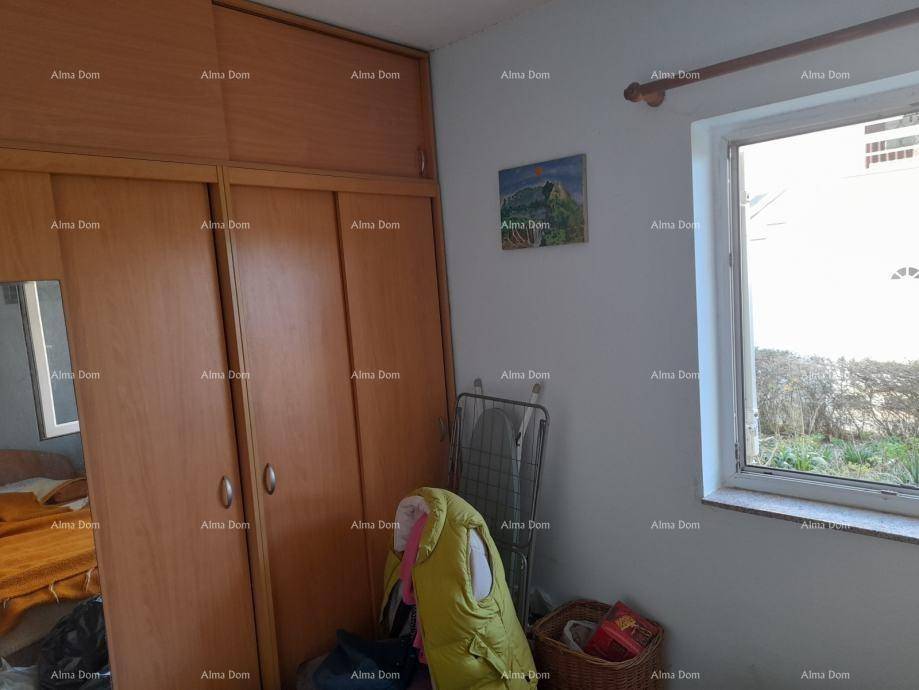 Schlafzimmer mit großem Holzschrank und Fenster, das den Blick nach draußen freigibt.