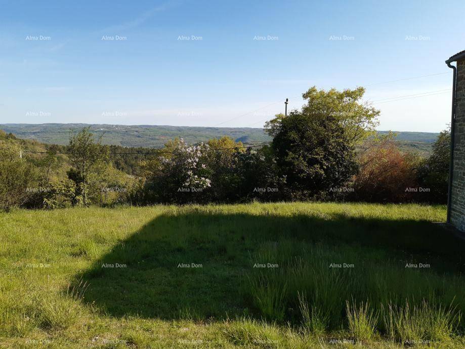 Weitläufige Grünfläche mit Blick auf die hügelige Landschaft unter klarem Himmel.