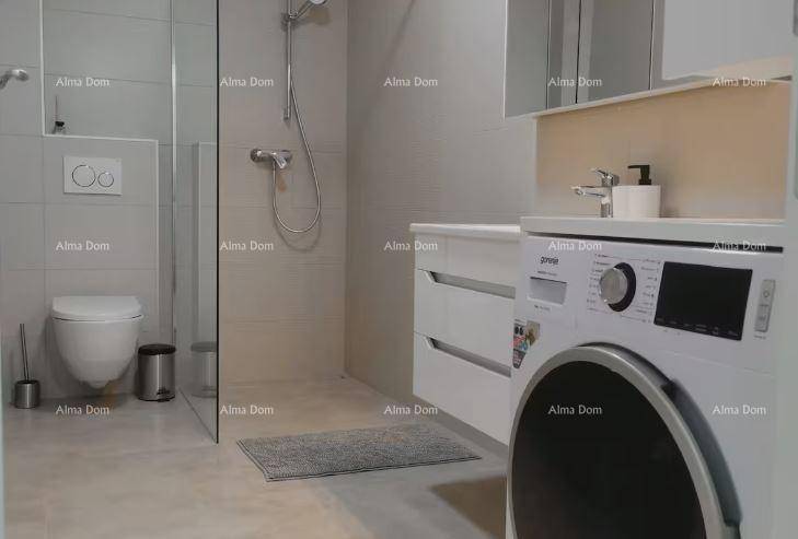 Funktionales Badezimmer mit ebenerdiger Dusche, Toilette und integrierter Waschmaschine.