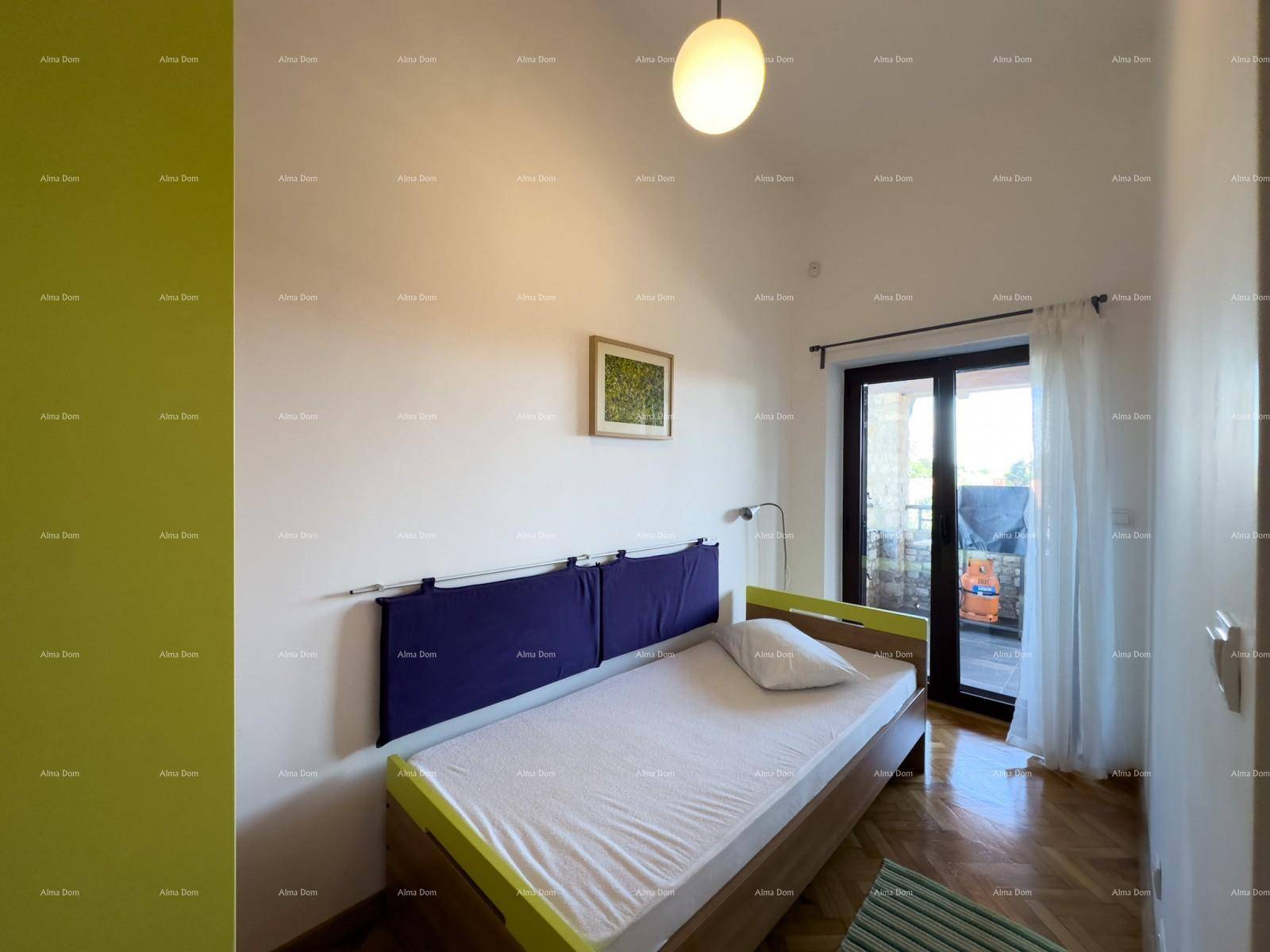 Helles Schlafzimmer mit Einzelbett, Holzboden und Zugang zu einem Außenbereich.