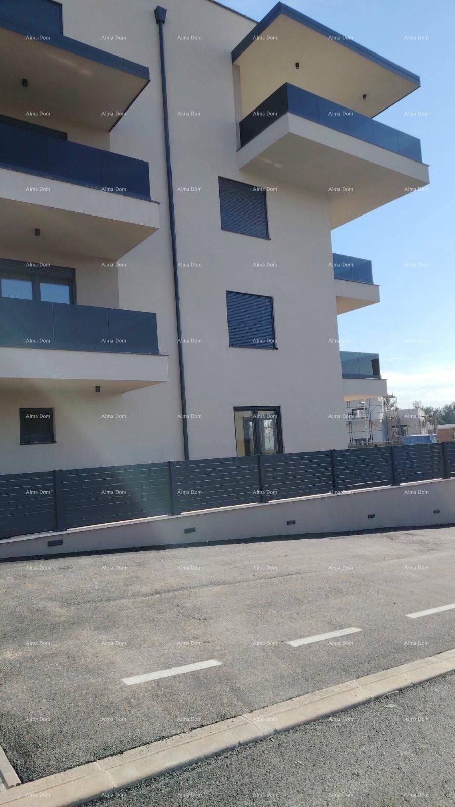 Seitenansicht des modernen Apartmentgebäudes mit Balkonen und einer Zufahrt.