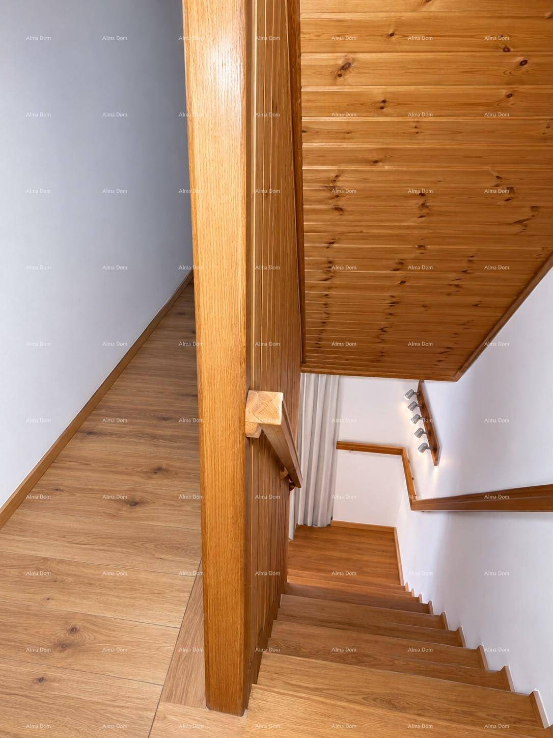 Heller Treppenaufgang mit Holzstufen und Holzvertäfelung an der Decke.