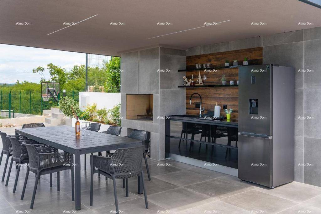 Überdachte Außenküche mit Essbereich, Grill und Kühlschrank für gesellige Stunden.