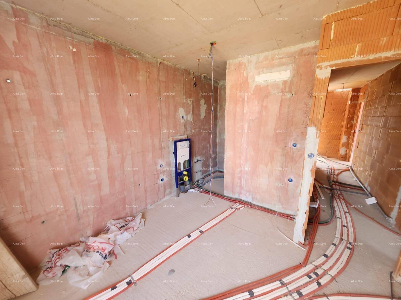 Innenraum im Rohbau mit Ziegelwänden, Betonboden und sichtbaren Elektroinstallationen auf dem Boden.