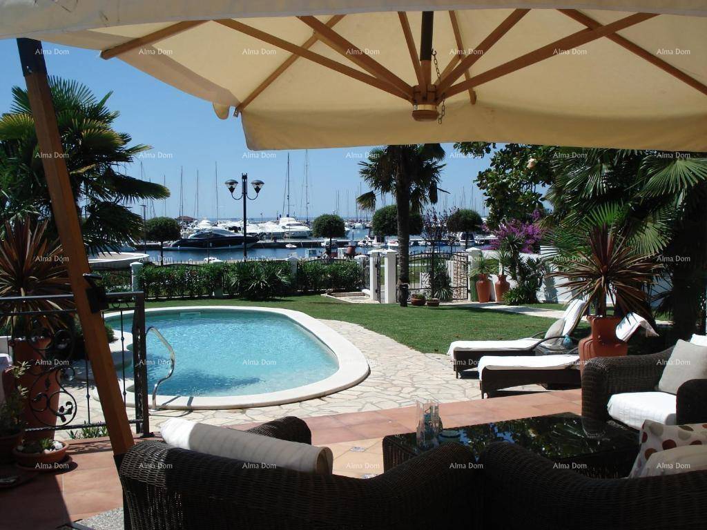 Gemütliche Terrasse mit Sitzgelegenheiten, Pool und Blick auf den Yachthafen.