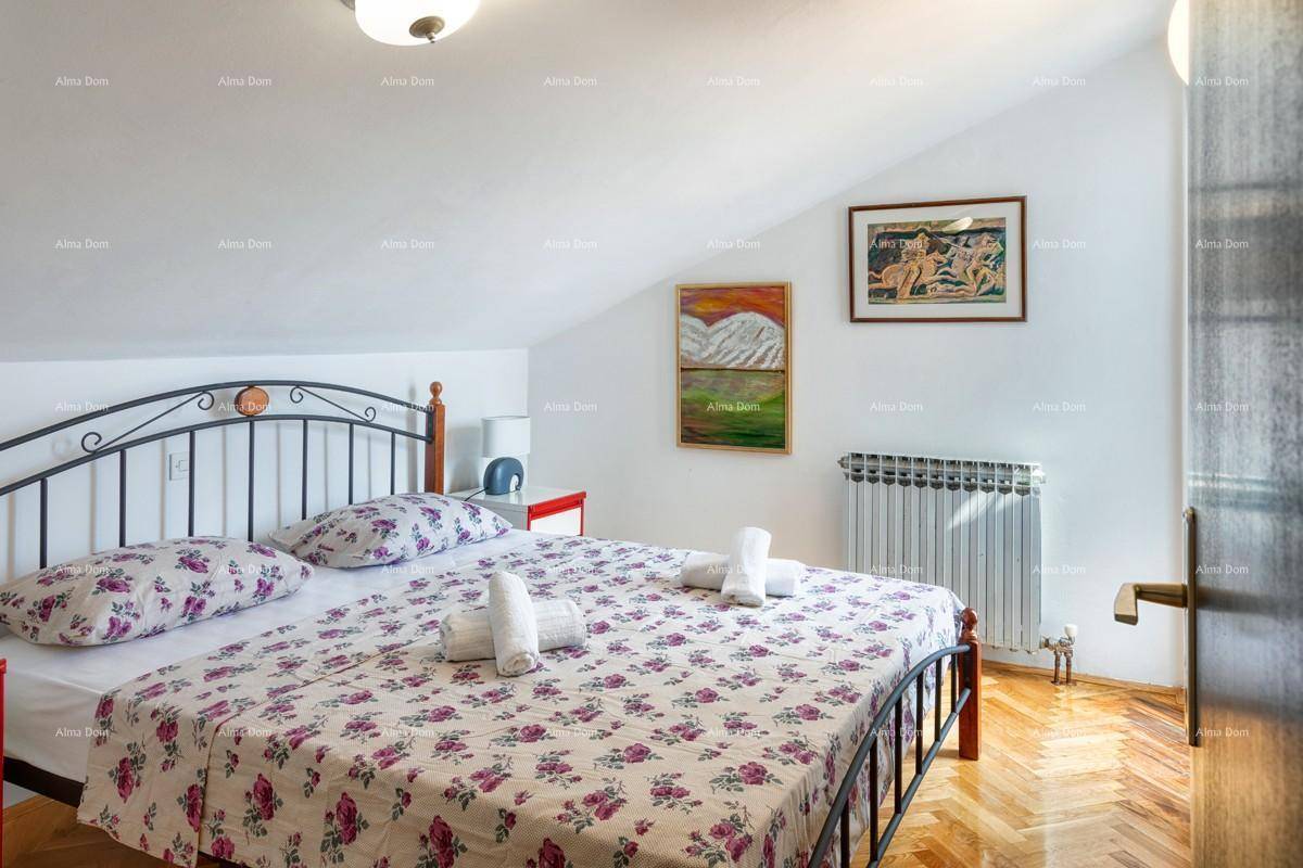 Schlafzimmer im Dachgeschoss mit Doppelbett, Holzboden und Dachschräge.