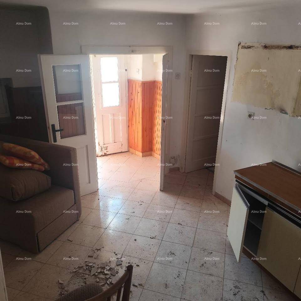 Innenraum in Renovierung mit Fliesenboden, offener Tür und sichtbaren Abnutzungsspuren.