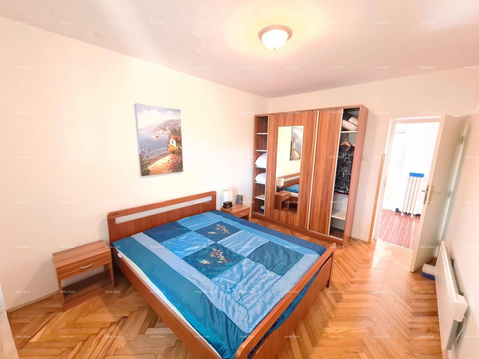 Helles Schlafzimmer mit Parkettboden, Doppelbett und großem Kleiderschrank.