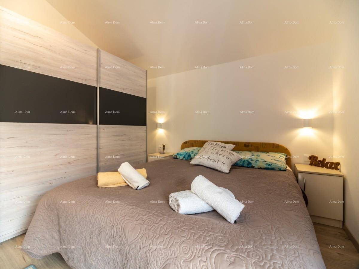 Schlafzimmer mit Doppelbett, großem Einbauschrank, Holzboden und indirekter Beleuchtung.