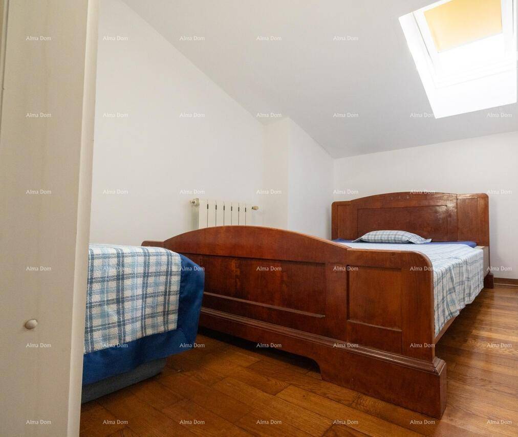 Gemütliches Schlafzimmer im Dachgeschoss mit Holzbett und natürlichem Licht durch das Dachfenster.