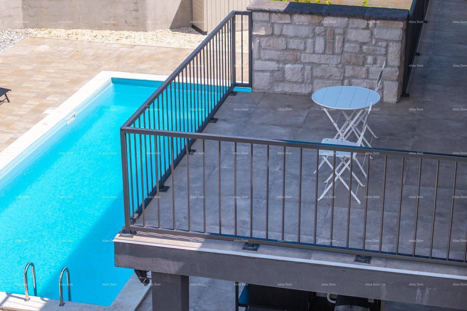 Kleiner Balkon mit Tisch und Stühlen, der einen direkten Blick auf den Pool bietet.