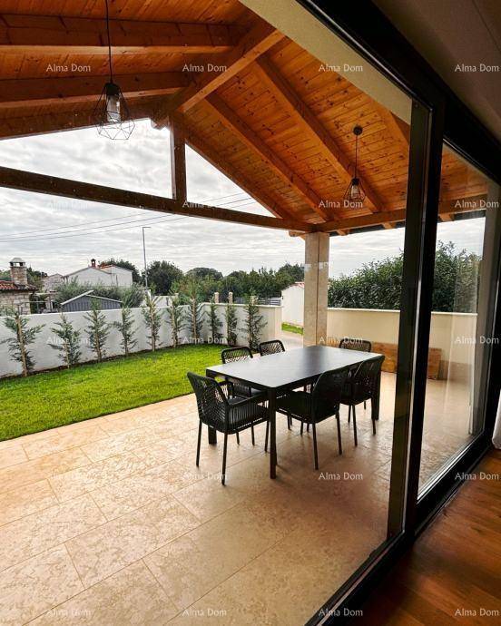 Geräumige überdachte Terrasse mit Esstisch und Zugang zum Innenbereich durch große Glasfront.