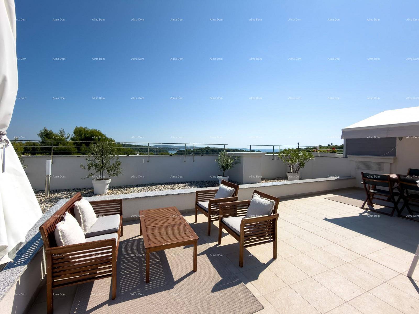Möblierte Dachterrasse mit Holzsitzgruppe und weitem Blick auf das Meer und die Umgebung.
