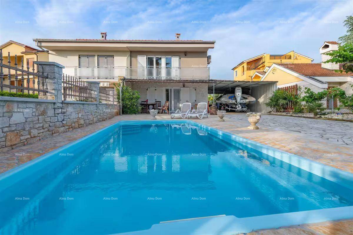 Außenansicht des Hauses mit großem Poolbereich und überdachtem Stellplatz für ein Boot.