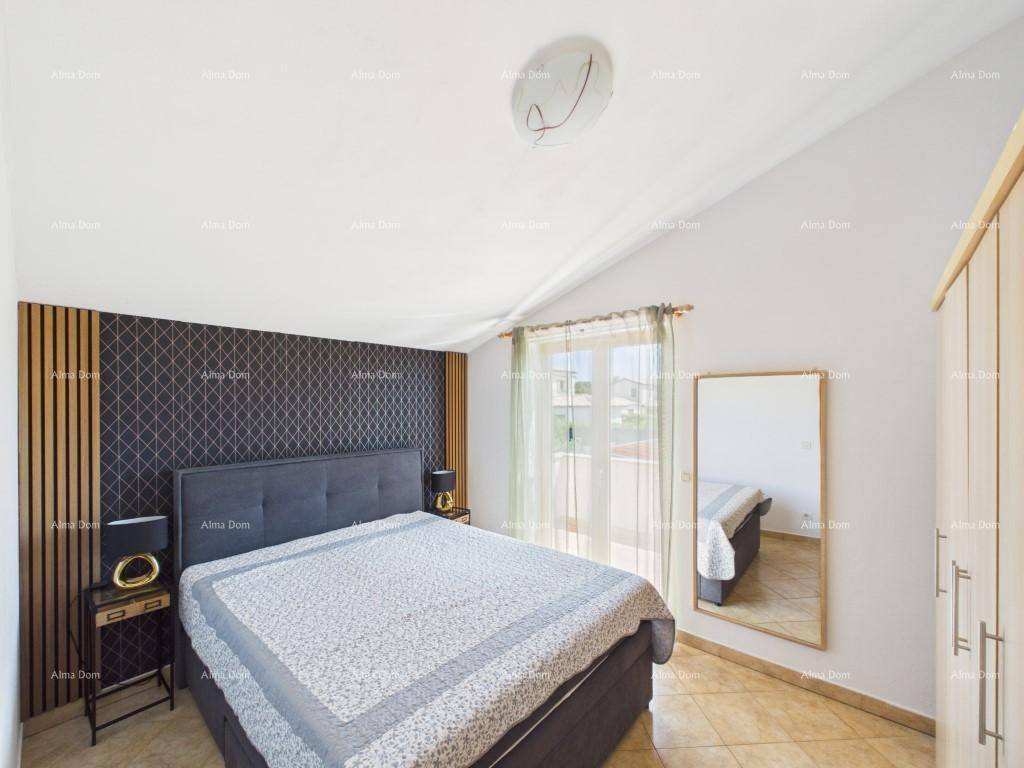 Modernes Schlafzimmer mit großem Bett, Holzboden und Zugang zu einem Balkon oder einer Terrasse.