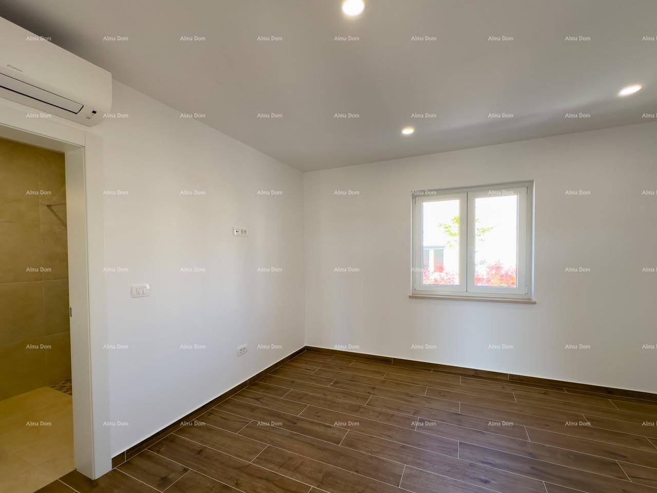 Helles Schlafzimmer mit Holzfliesenboden, Klimaanlage und direktem Zugang zum Badezimmer.