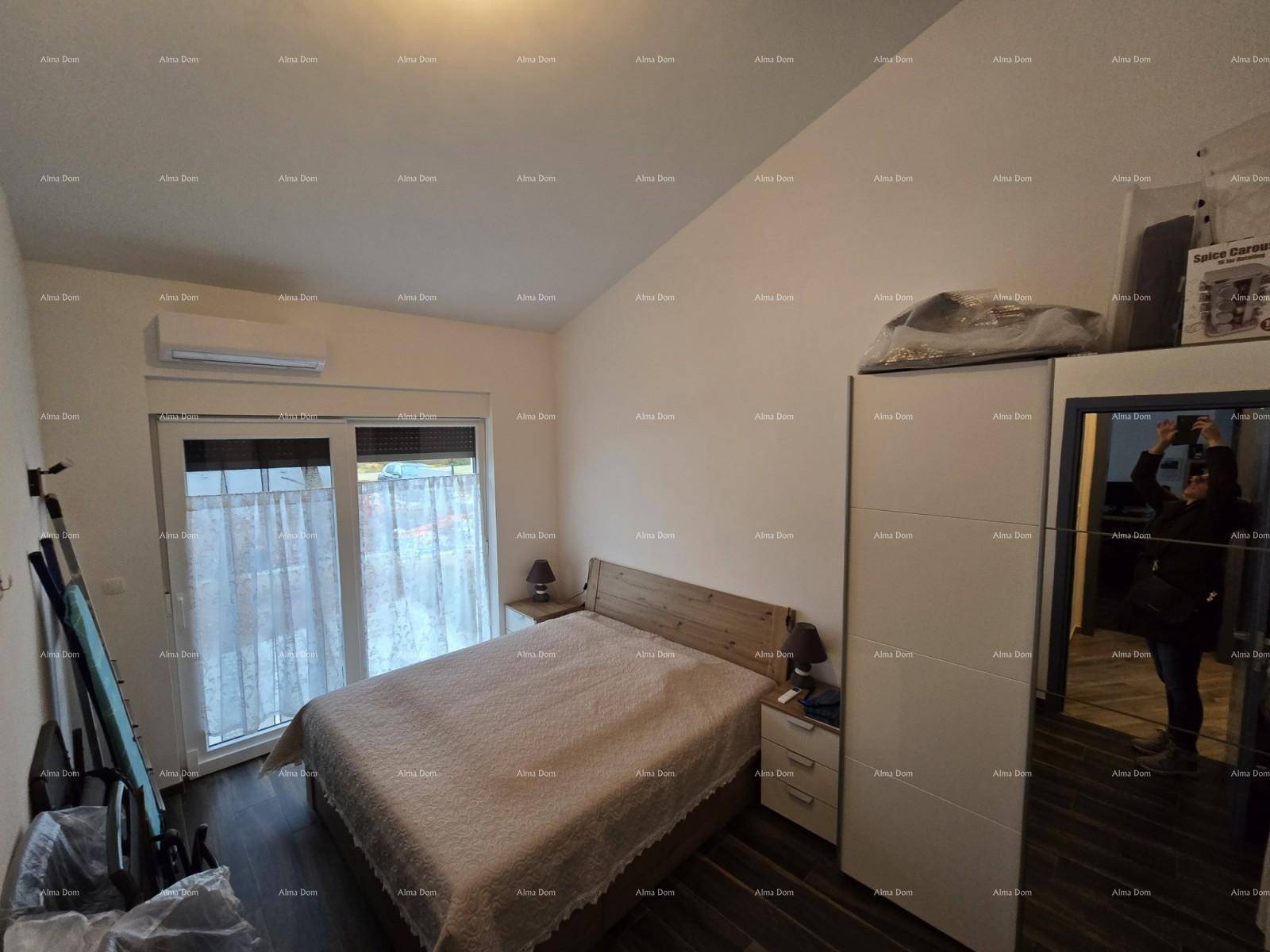 Schlafzimmer mit Doppelbett, Kleiderschrank und Zugang zur Terrasse.