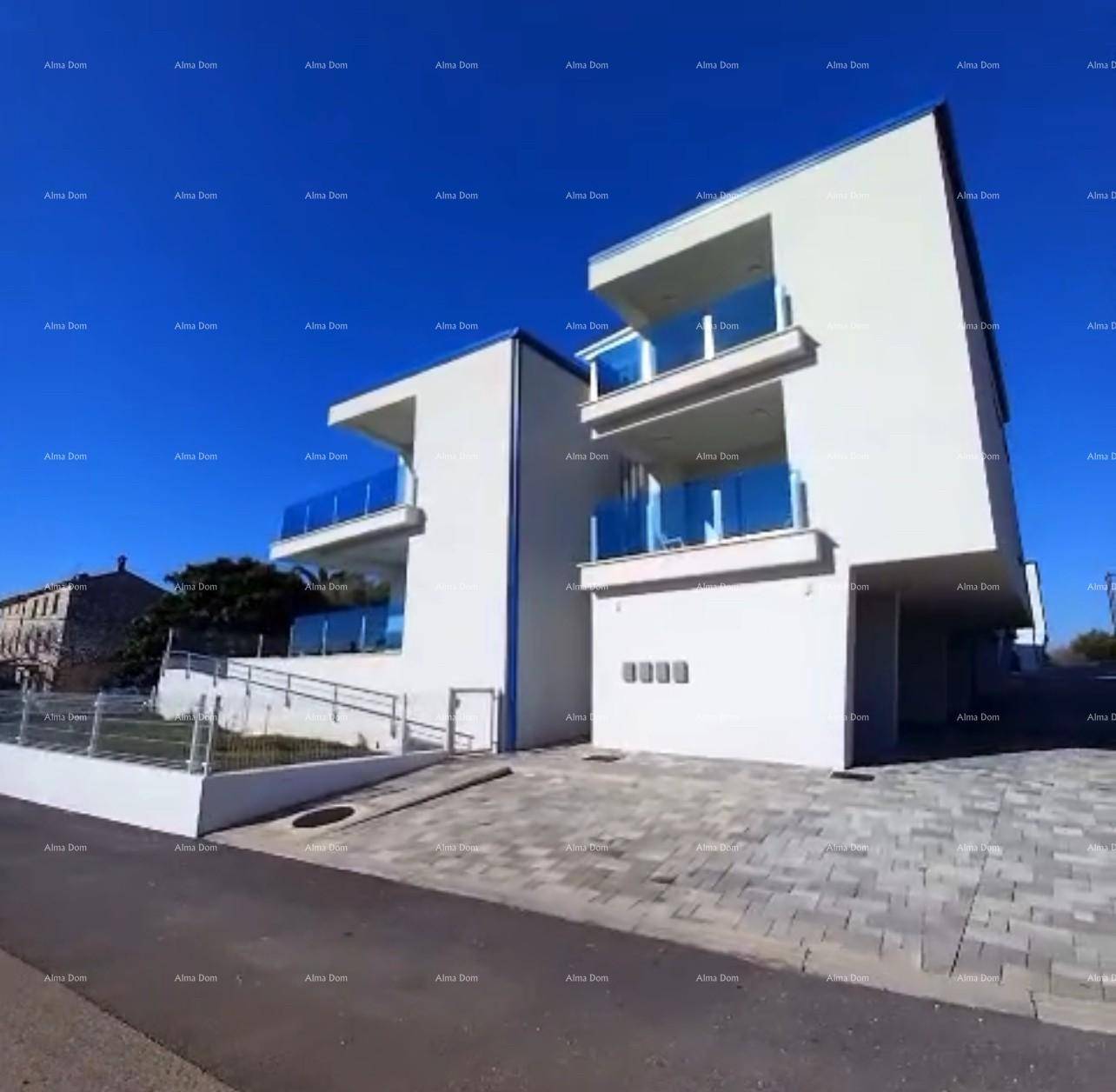 Modernes weißes Gebäude mit blauen Glasbalkonen und gepflastertem Vorplatz unter blauem Himmel.