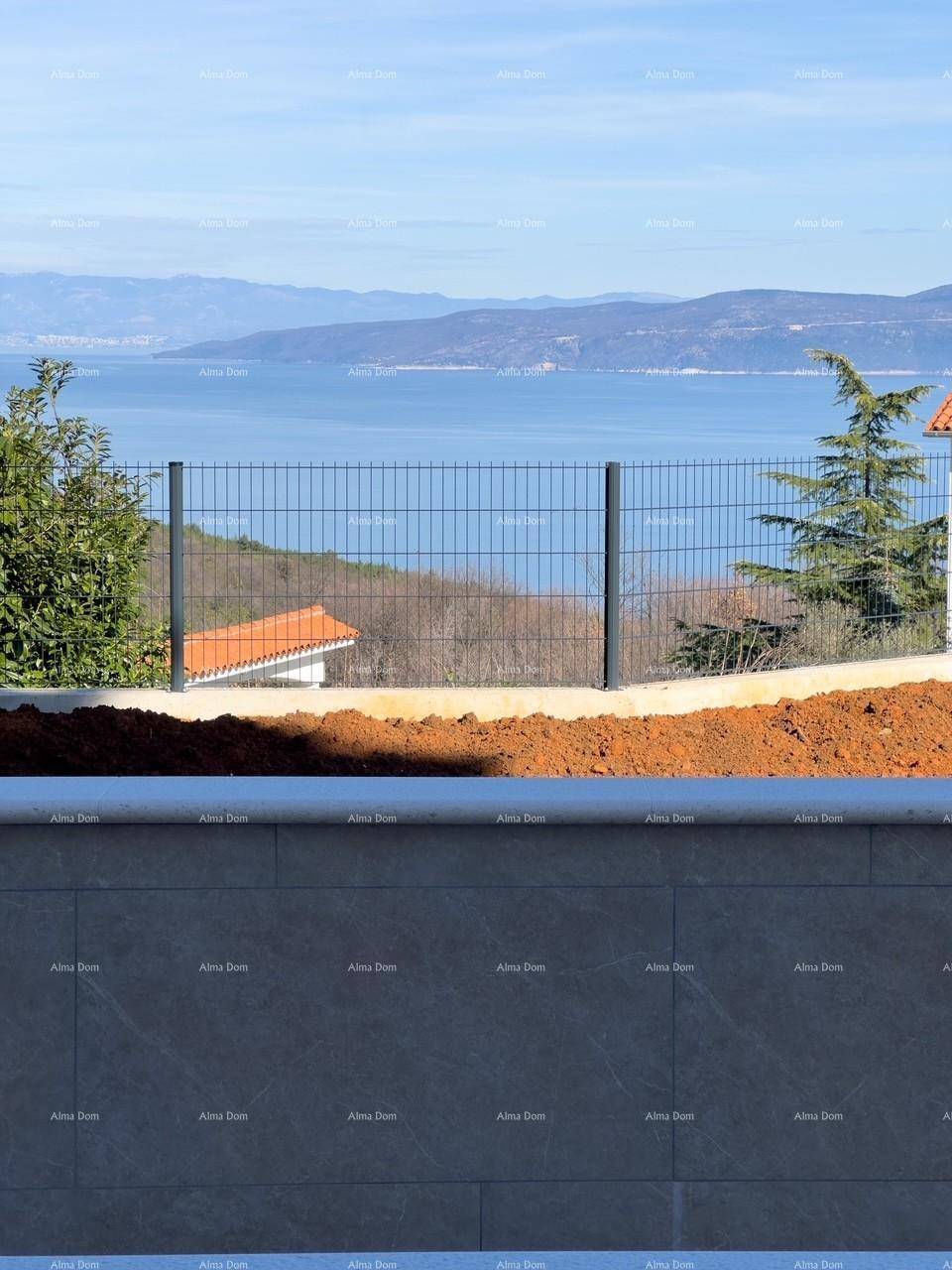 Weitläufiger Meerblick durch den modernen Zaun, umgeben von grüner Landschaft.