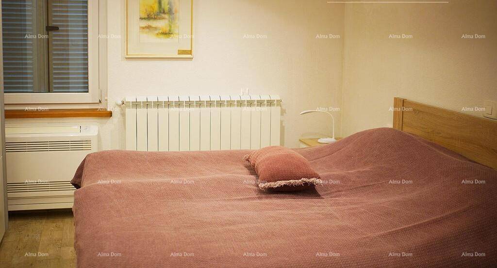 Schlafzimmer mit Doppelbett, Heizkörper unter dem Fenster und einer zusätzlichen Wandheizung.