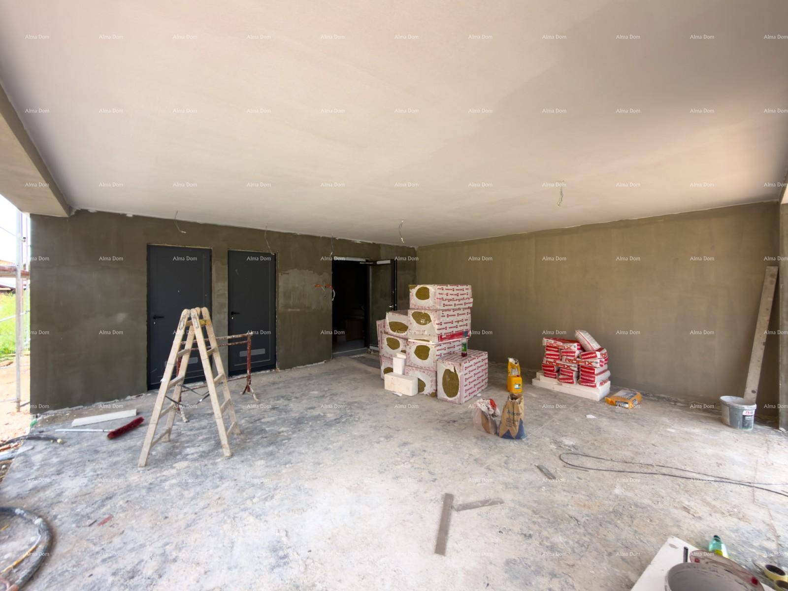 Großer unfertiger Innenraum mit Betonboden, verputzten Wänden und Baumaterialien.