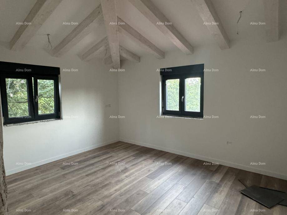 Schlafzimmer im Dachgeschoss mit sichtbaren Holzbalken, zwei Fenstern und Holzboden.