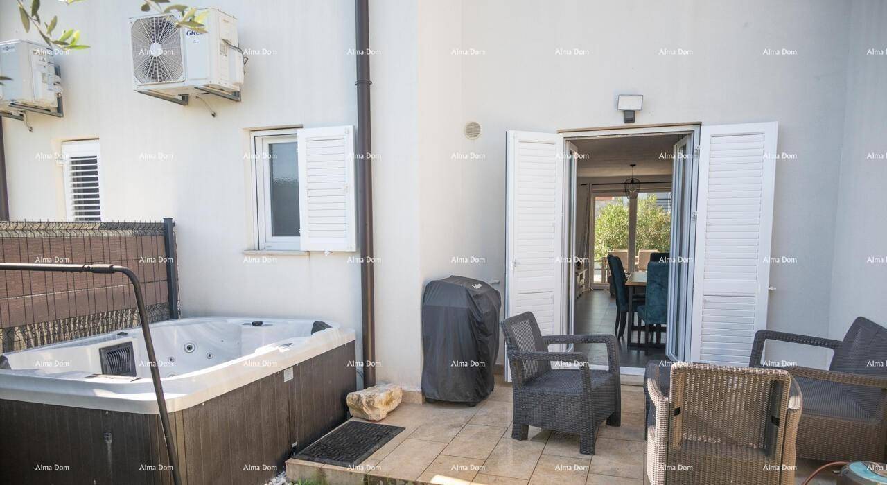 Außenbereich mit Whirlpool, Sitzgelegenheiten und Zugang zum Innenbereich durch eine Terrassentür.