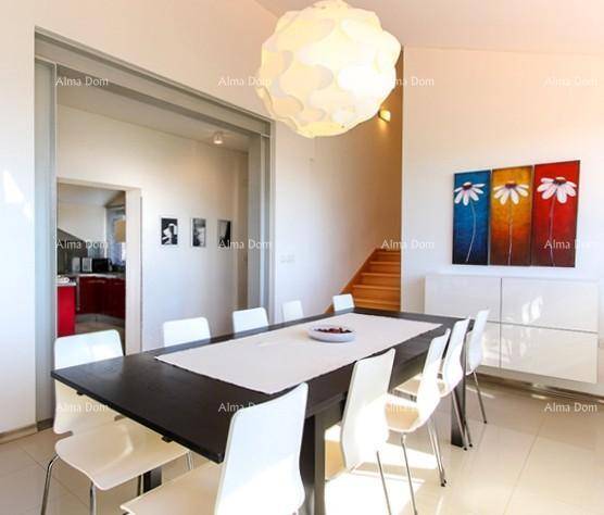 Heller Essbereich mit großem Tisch, Kunst an der Wand und Übergang zur Küche.